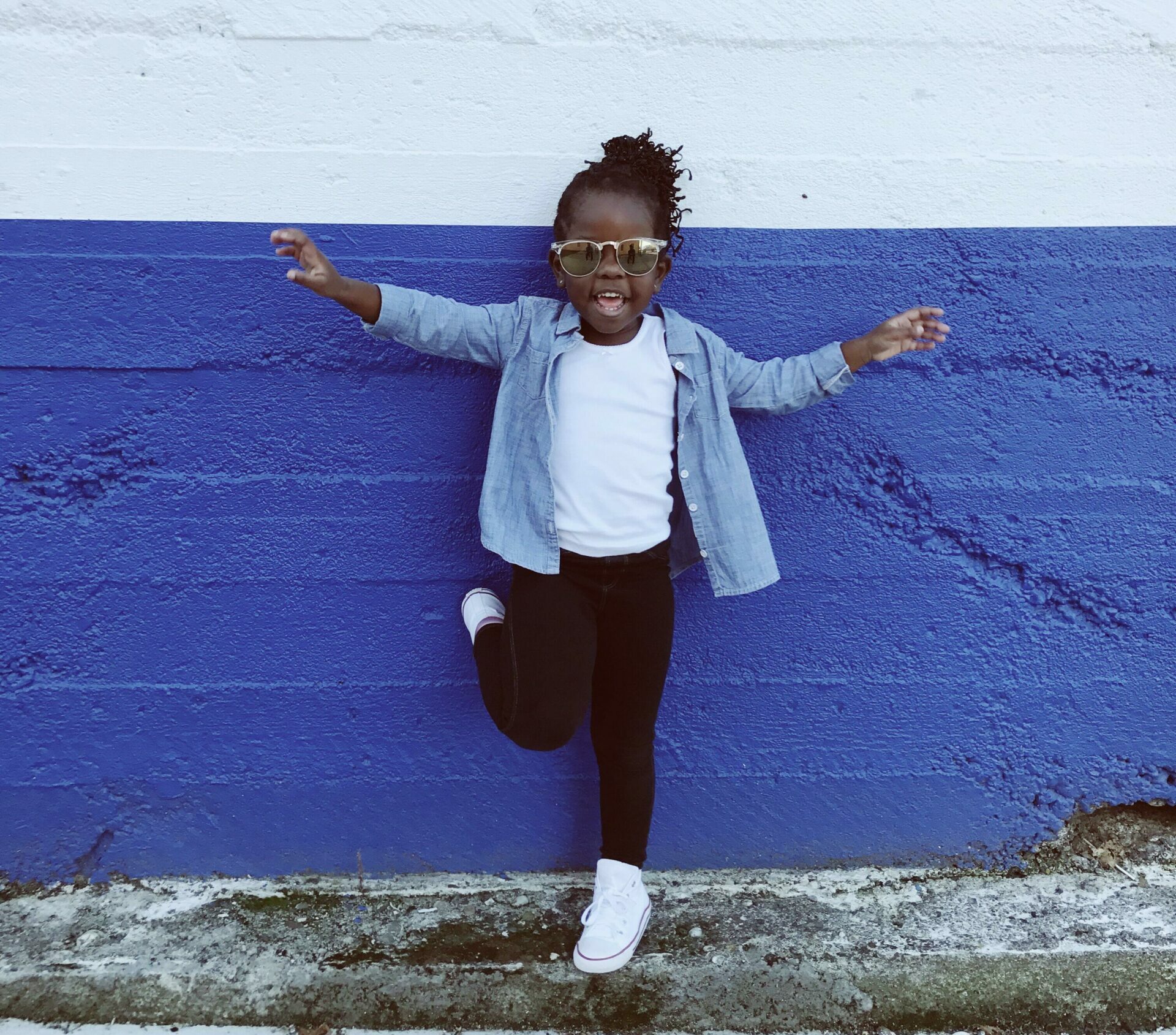 young girl standing against wall