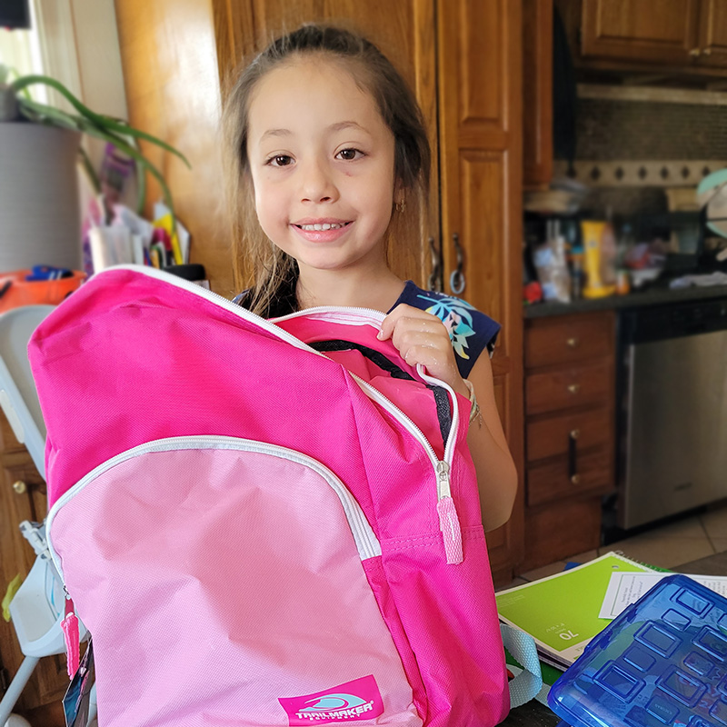 child receiving backpack