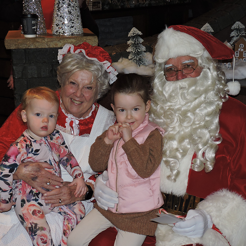 Santa and Mrs. Claus pose with children at Red Stocking Breakfast Kansas City 2025.