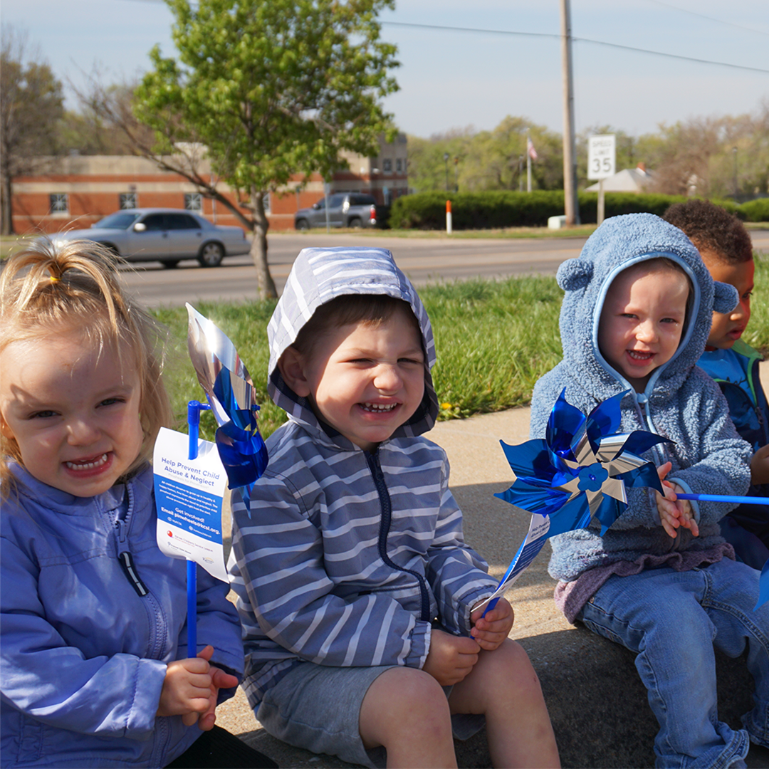 children wearing blue and holding pinwheels for CAP Month